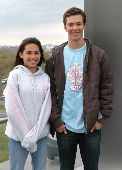 A young woman and young man stand near each other outdoors.