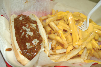 A chili dog and French fries with cheese.  