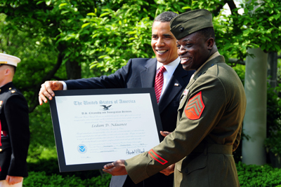 Two men, one in a military uniform and one in a suit, hold a plaque that indicates citizenship.