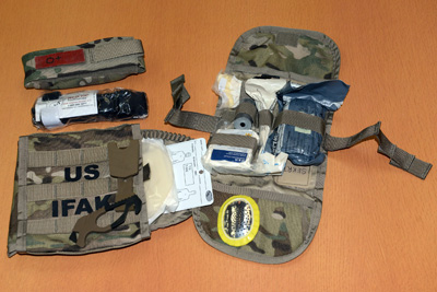 A camouflage kit contains medical supplies.  One part of the kit says "US IFAK." 