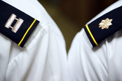 The epaulettes on the shoulders of two military officers display the ranks of captain and major.