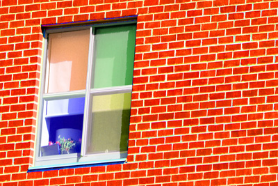 A red brick wall has a four-panel window. Each panel of the window is tinted a different color: red, green, blue and yellow.  Behind the blue panel is a flower pot.