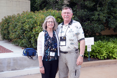 A man and a woman stand near each other outdoors.