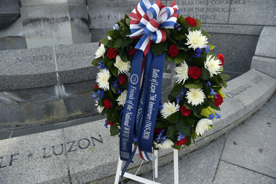 A wreath sits in front of stonework. The word "Luzon" appears on the stonework.